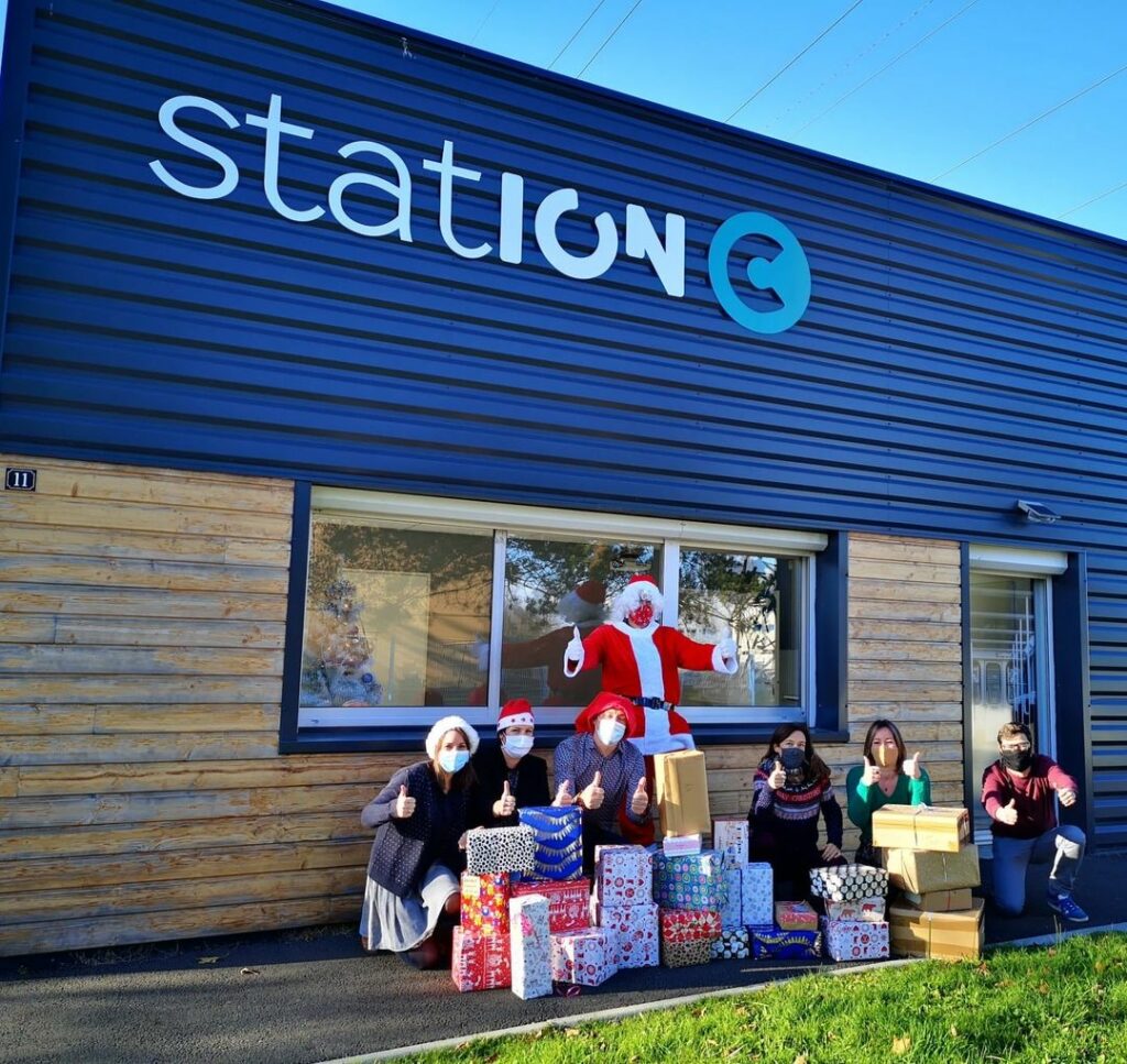 Photo de groupe avec le père Noël et les cadeaux pour les Boîtes Solidaires de Noël 2022